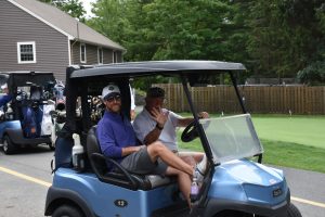 Two men sitting in a golf cart